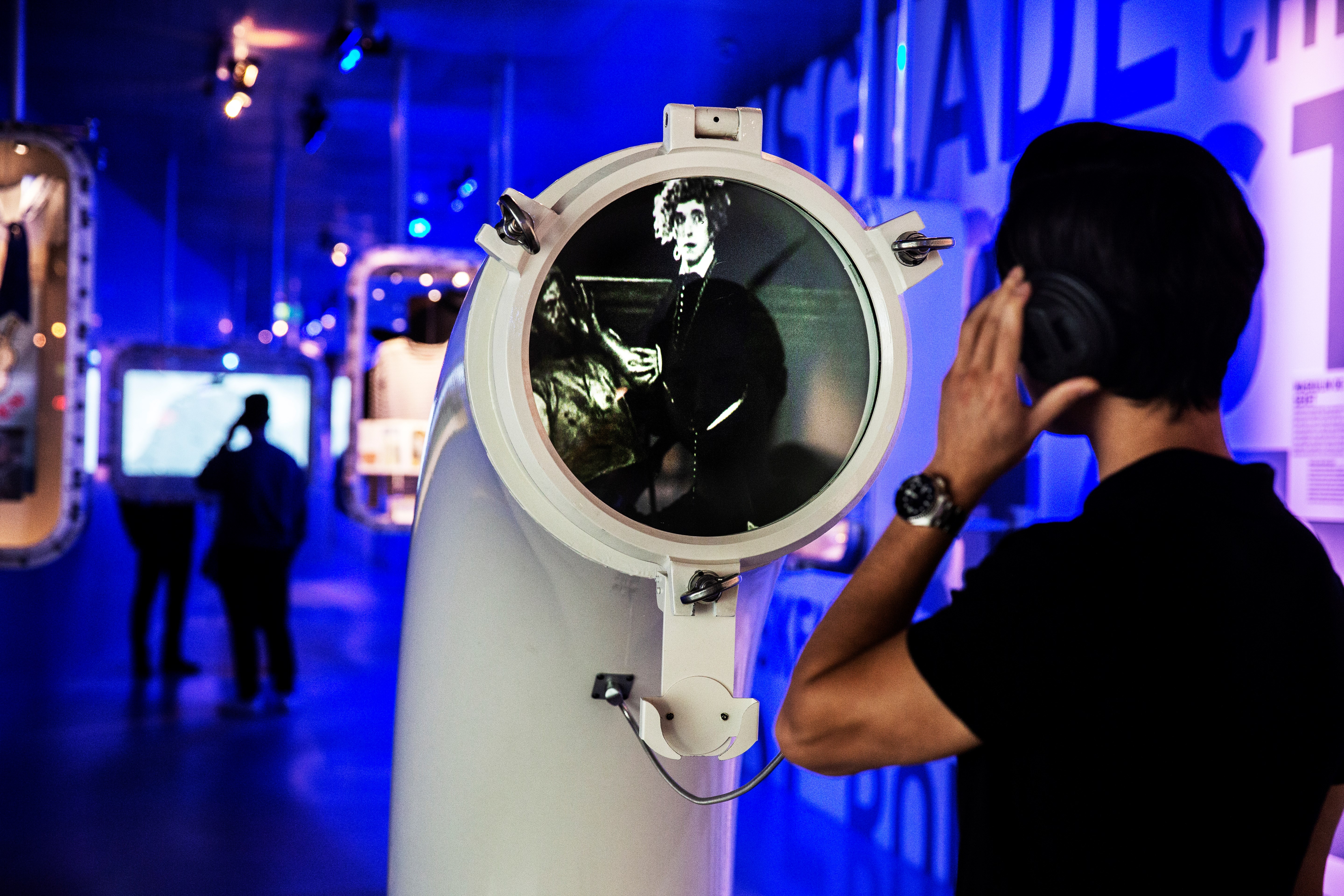Mand lytter til visuel fremstilling på et museum