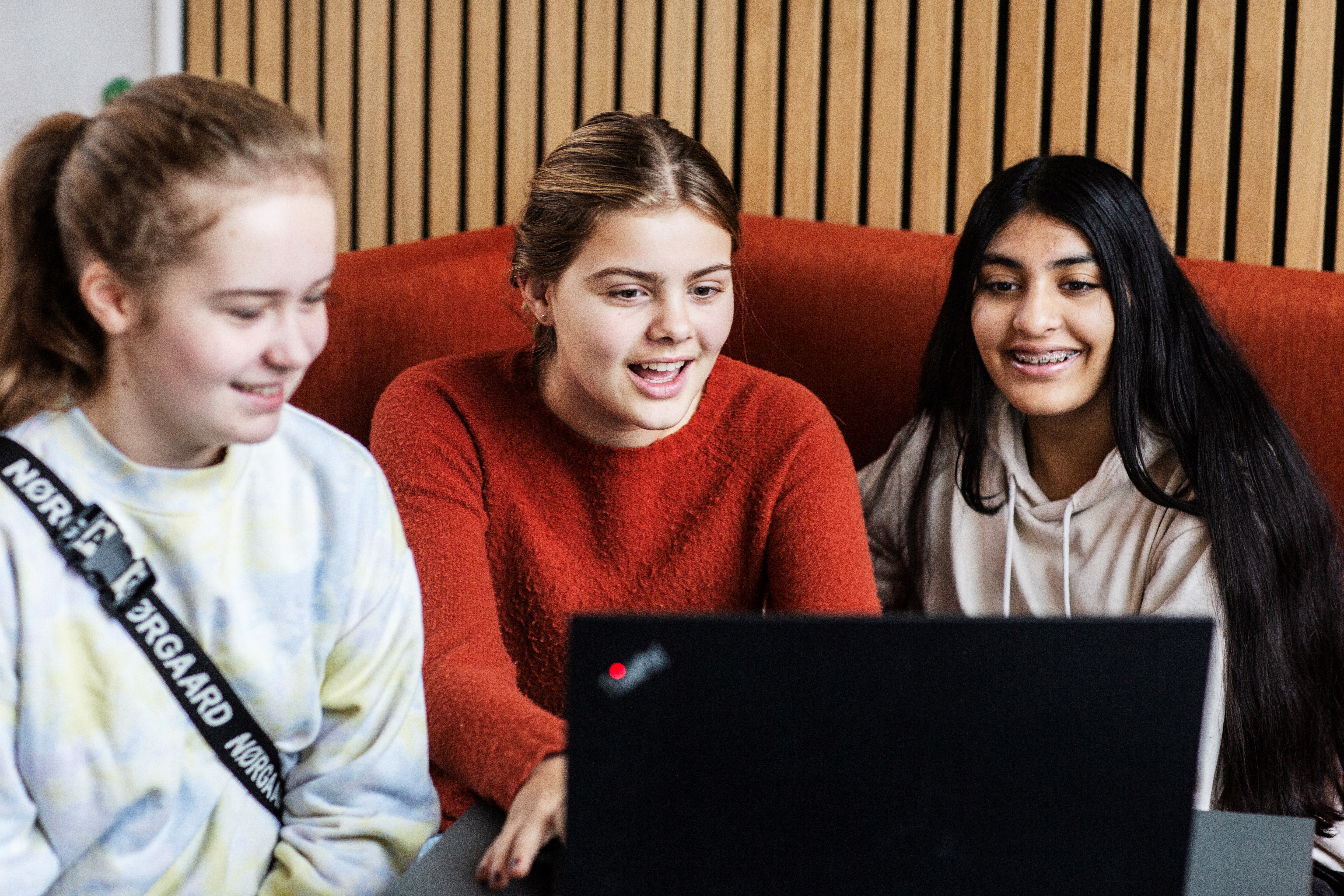 Tre skolepiger ser film på en computer
